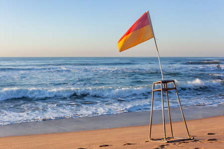 Morning beach ocean with lifeguard swimming beacon flags out early for a swimming designated area...