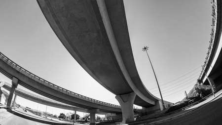 Road Highway Intersection over pass ramp entry exit flyover ramp in abstract urban black white photo.の写真素材