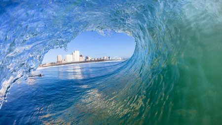 Durban swimming inside hollow ocean wave tube crashing water power a surfing landscape perspective.の写真素材