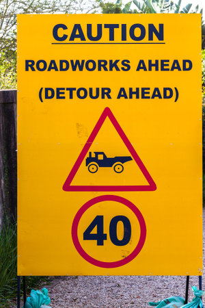 Road Caution warning sign words Roadworks Detour Ahead. Close-Up Yellow and Black detail.の写真素材
