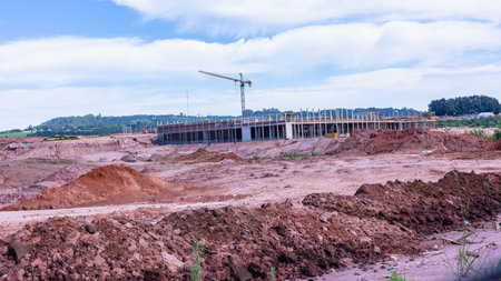 New construction of shopping centre in countryside halfway concrete colums, crane, scaffolding and earthworks in rural countryside.の写真素材