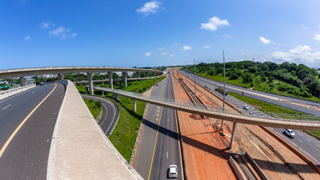 Driving road highway overhead ramps through construction expansion improvements with barriers, earthworks, new lanes for vehicle traffic flow landscape.の写真素材