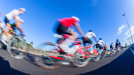 Cycling riders close-up morning dawn motion speed blur unrecognizable cyclists on coastal road highway.の写真素材