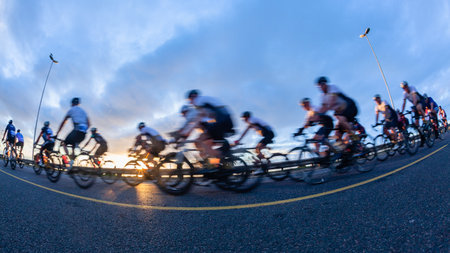 Cycling riders close-up morning dawn motion speed blur unrecognizable cyclists peleton on coastal road race highway.の写真素材