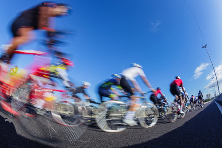 Cycling riders close-up morning dawn motion speed blur unrecognizable cyclists on coastal road highway.の写真素材