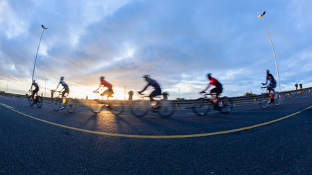 Cycling riders close-up morning dawn motion speed blur unrecognizable cyclists on coastal road highway.の写真素材