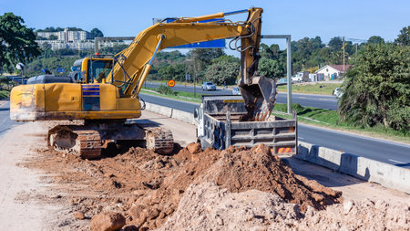 Industrial construction road highway expansion heavy excavator machine tipping earth soil sand into...
