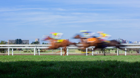 Horses riders racing running motion speed blur grass track photograph.