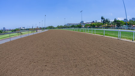 Horse racing track standing inside railing on poly section perspective on a clear blue dayの写真素材