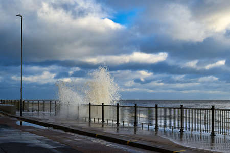 Waves crash up against a promenadeの写真素材