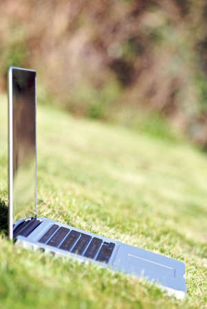 Laptop outside on the grass in summer.の写真素材