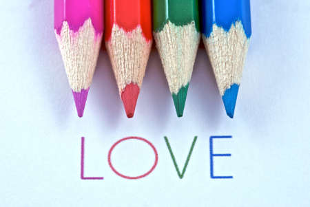 4 colored pencils with the word love written below.の写真素材