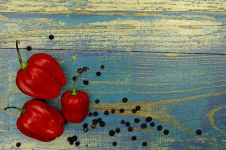 composition of three chili peppers on wood backgroundの写真素材