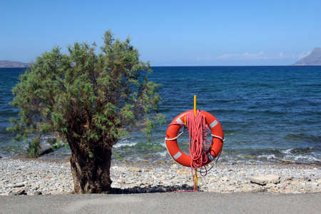 Lifebuoy on the rocky beachの写真素材