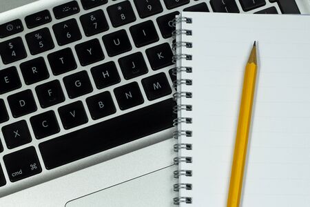 Notebook with pencil on modern laptopの写真素材