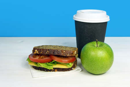 Healthy lunch with sandwich, green apple and coffee in paper cupの写真素材
