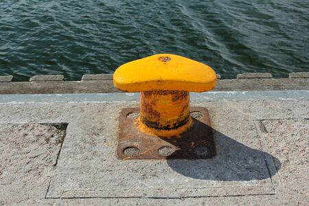 yellow rusty mooring bollardの写真素材