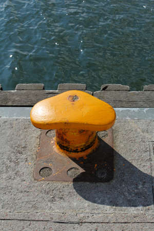 yellow rusty mooring bollardの写真素材