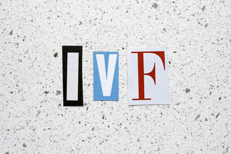 IVF (In Vitro Fertilization) acronym cut from newspaper white handmade paper textureの写真素材