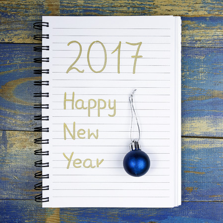 Happy New Year 2017 written in the notebook and christmas bauble