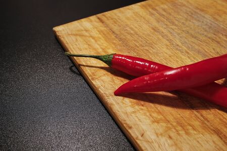 red chili peppers on wooden cutting boardの写真素材