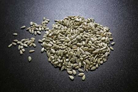 shelled sunflower seeds on black backgroundの写真素材