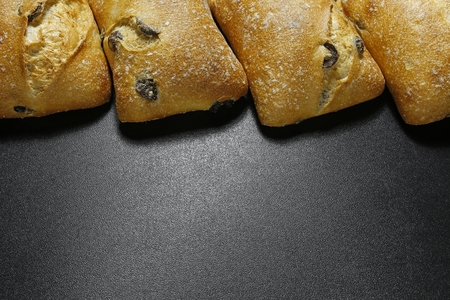olive ciabattas on black background with copy space