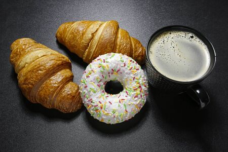 croissant, donut and coffee on black backgroundの写真素材