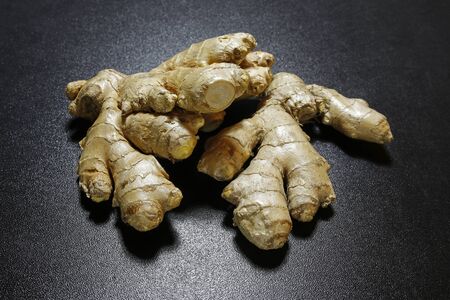 Ginger root on black shiny backgroundの写真素材
