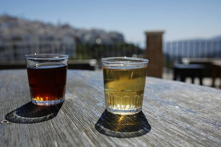 glasses of red and white wine on old oak barrel with landscape in the backgroundの写真素材