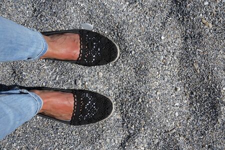 summer vacation selfie suntanned female feet on a rocky beachの写真素材