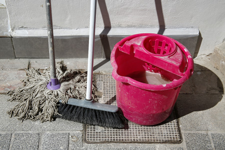 pink bucket, mop, brush on the streetの写真素材