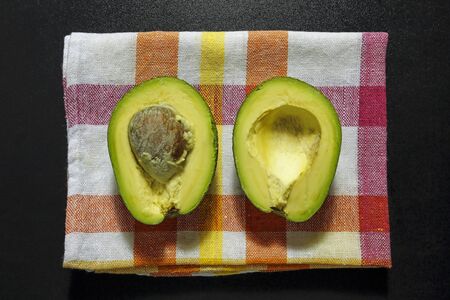 Halved avocado on kitchen cloth