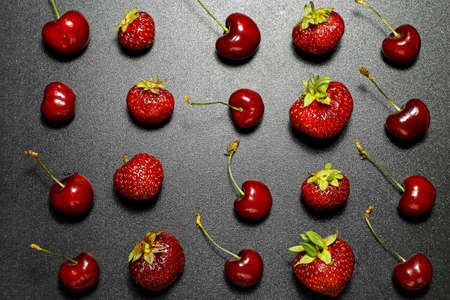 Strawberries and cherries on dark backgroundの写真素材