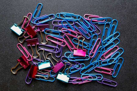 Colorful paper clips on black background