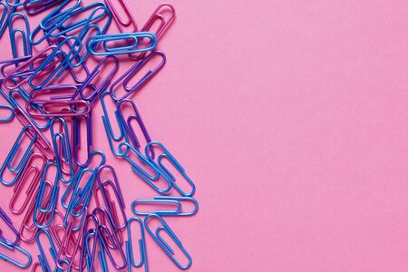 Colorful office paper clips on pink background with copy spaceの写真素材