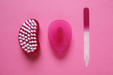 Nail file, brush and rubber face cleaner on pink backgroundの写真素材