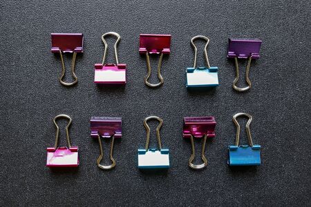 Flat lay of the office paper clips on black shiny backgroundの写真素材