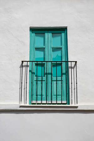 Turquoise balcony door in whitewashed wallの写真素材