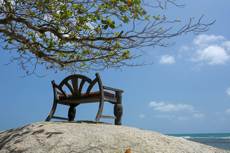 wooden bench overlooking turquoise seaの写真素材