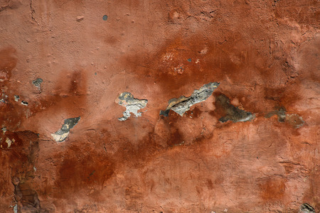 old peeling red stone wall