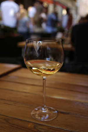 closeup of white wine glass at the table of street cafeの写真素材