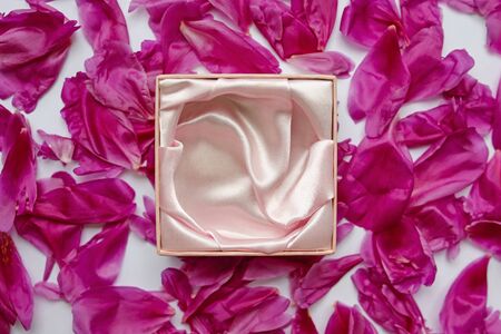 empty jewelry box on beautiful peony petalsの写真素材