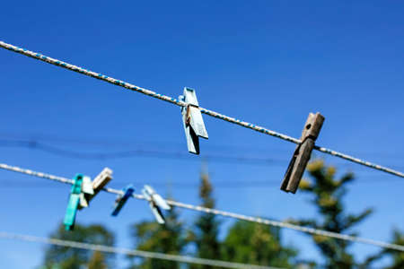 colorful clothespins on the rope against blue sky with selective focusの写真素材