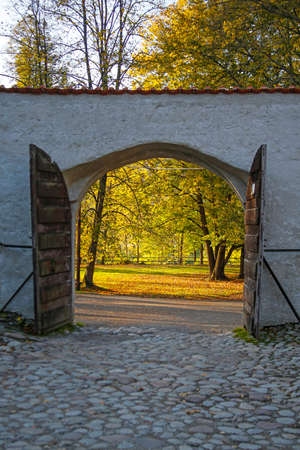 beautiful autumn park seen through open historic gateの写真素材