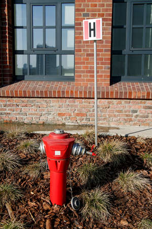 red fire hydrant in front of brick buildingの写真素材