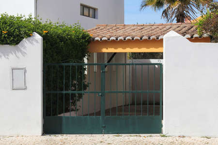 green metal gate in white wall