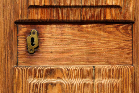 closeup of golden keyhole in elegance wooden doorの写真素材