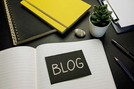 blog written on black paper card on open notebookの写真素材