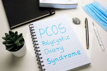 PCOS Polycystic ovary syndrome written in spiral notebook on doctor desk
